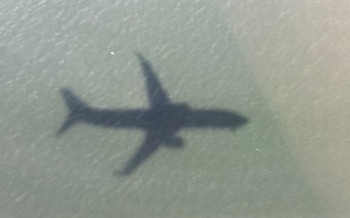 sombra do avião no mar, visto de cima