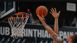 imgem mostra apenas as mãos de jogadores disputando uma bola de basquete ao lado da cesta.