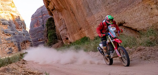 piloto de moto passa ao lado de uma parede de pedra durante edição do rally dos Sertões