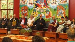 imagem do evento cento e oito horas pela paz realizado em 2018. em frente a um painel, diversos monges sentados lado a lado.
