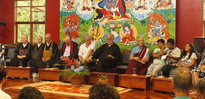 imagem do evento cento e oito horas pela paz realizado em 2018. em frente a um painel, diversos monges sentados lado a lado.