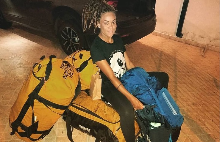 Aretha Duarte, sentada sobre sua bagagem, rumo ao Everest.