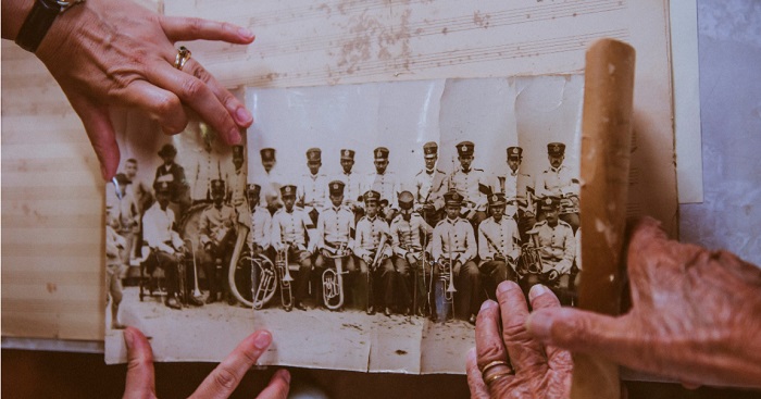 imagem de mãos segurando uma foto antiga de uma banda