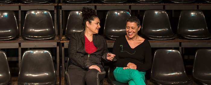 imagem de duas mulheres sentadas em uma plateia vazia de teatro, uma das peças indicadas na programação cultural online do fim de semana