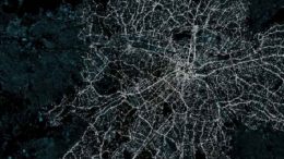 imagem de satélite mostrando ruas iluminadas da cidade, como em uma teia de aranha.