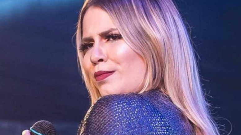 imagem fechada da cantora Marília Mendonça, ela olha de lado sobre os ombros.