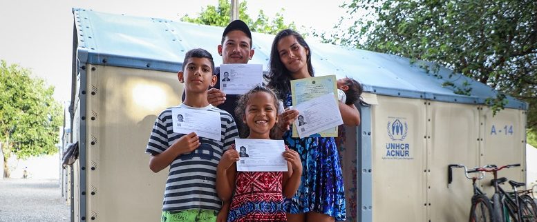 Família venezuelana com sua documentação em centro de registro em Boa Vista. © ACNUR/Allana Ferreira