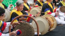 pessoas sentadas no chão tocando tambores samulnori