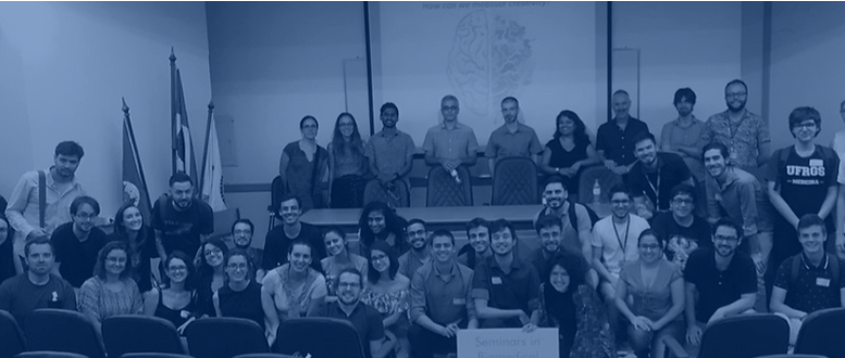 imagem azulada de grupo de alunos (mentorados de Yale) posando para a foto em frente a uma enorme lousa