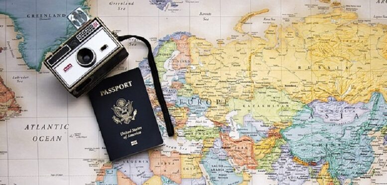 mapa mundi com câmera fotográfica e passaporte em cima