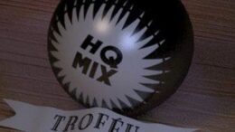 imagem do trofeu que parece uma bomba, preta, escrito HQ MIX e embaixo uma faixa com a palavra troféu
