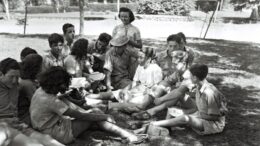 imagem em preto e branco de jovens sentados na grama na sombra de uma árvore
