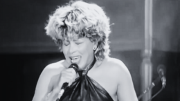 imagem em preto e branco de Tina Turner cantando no palco