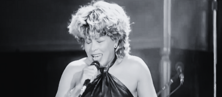 imagem em preto e branco de Tina Turner cantando no palco