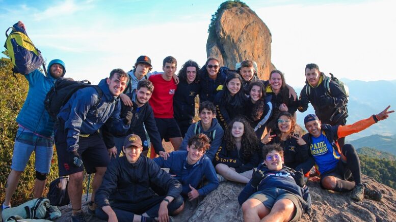 acampantes do Paiol Grande posam para foto em cima do Bauzinho, com a Pedra do Bau ao fundo