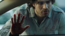 cena do filme paixões assassinas, com o protagonista masculino com a mão ensanguentada no vidro da janela do carro