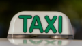 imagem de um luminoso de táxi de colocar no teto do carro, com as letras em verde.