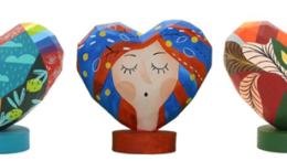 cinco estatuetas de coração, de modelo padrão em uma base redonda cada uma. cada uma desenhada/decorada em um estilo diferente por um artista plástico diferente.