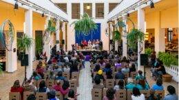 imagem de um hall com muitas cadeiras posicionadas como publico voltadas a uma mesa no fundo com apresentadores, na ediçãõi 2018 do evento