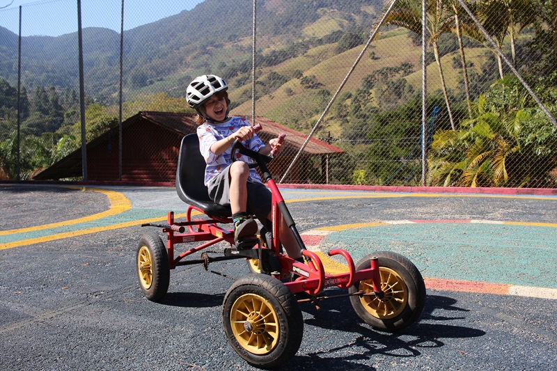 garoto pedalando um quadriciclo no Paiol