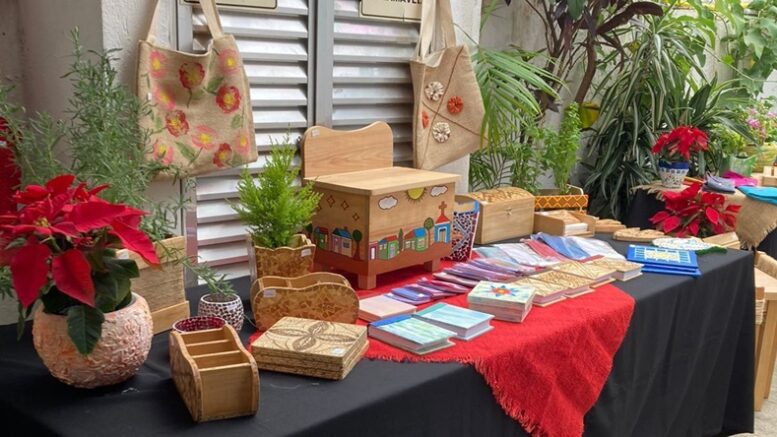 mesa dos artesãos da alterntiva no bazar com várias peças em madeira