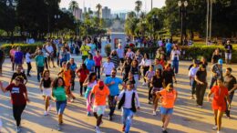 grupo de pessoas dançando no parque independência, de costas para um monumento