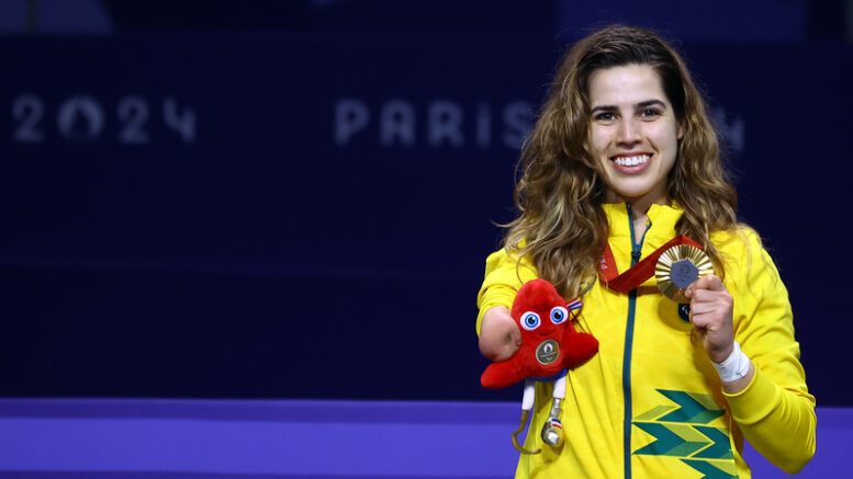 carol moura mostra a medalha de ouro.