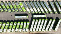 frota de ônibus elétricos vista de cima, vários com placas de captação de energia solar