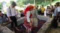 pessoas vestidas em trajes típicos portugueses pisando a uva em uma espécie de piscina, chamada de lagar.