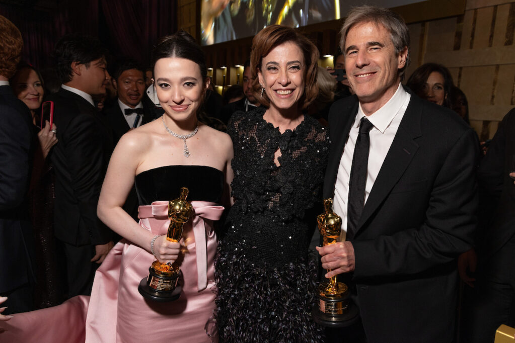 Mikey Madison, vencedora como melhor atriz posa com Fernanda Torres e Walter Salles