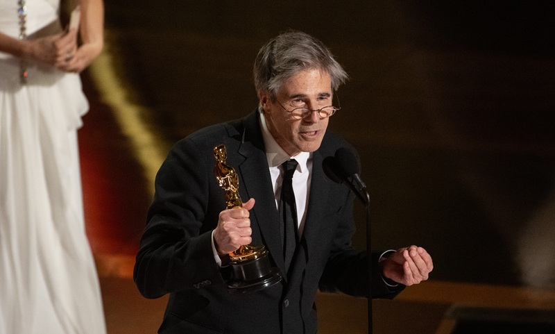 Walter Salles em seu agradecimento pelo Oscar, com uma estatueta na mão, falando ao microfone