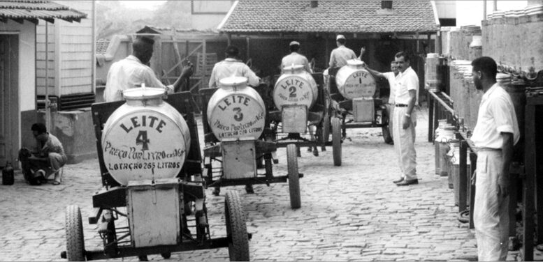 foto antiga de carrocinhas de leite (galões em estrutura com rodas)