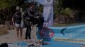 homem com roupa de merguoho joga lixo plástico sobe uma lona com a logomarca da embalixo