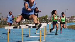 imagem de meninas em uma pista de corrida com barreiras.