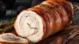 rocambole de carne de porco enrolada, temperada e cozida.