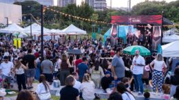 publico sentado e em pé, ao ar livre, em frente a um palco com a identificação do festival de jazz