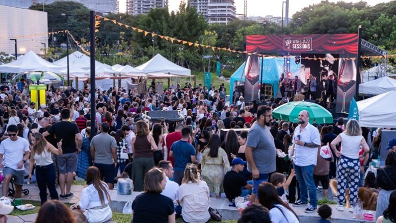 publico sentado e em pé, ao ar livre, em frente a um palco com a identificação do festival de jazz