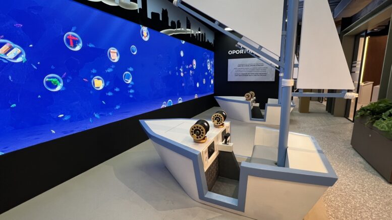 duas estruturas imitando barcos a vela, voltadas para uma parede azul com marcas pintadas