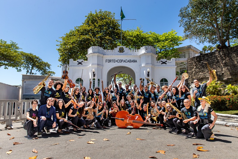 imagem dos musicos da orquestra posando em frente ao pórtico de entrada do Forte de Copacabana