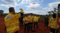 imagem de grupo de brigadistas com uniformes amarelos, em campo