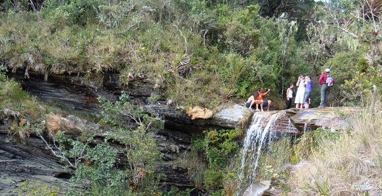 imagem de grupo de turistas no topo de uma das quedas d'água do Ibitipoca.