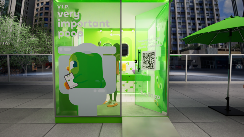 banheiro com paredes de vidro e tons de verde, além do deseho da coruja do duolingo, em uma área aberta com pipso frio.