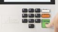 imagem do teclado da urna eletrônica com dedo feminino apertando a tecla 'confirma'.