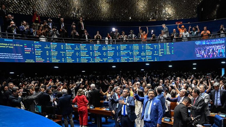 imagem do plenário do senado lotado, inclusive nas galerias com as pessoas comemorando.